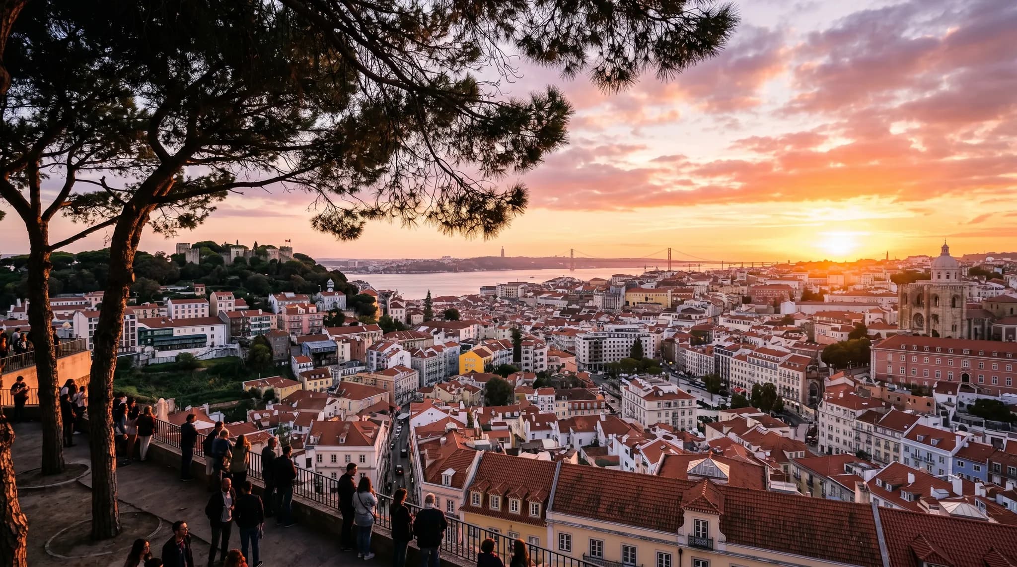 Sunset view over Lisbon from Miradouro da Graça with pine trees in foreground